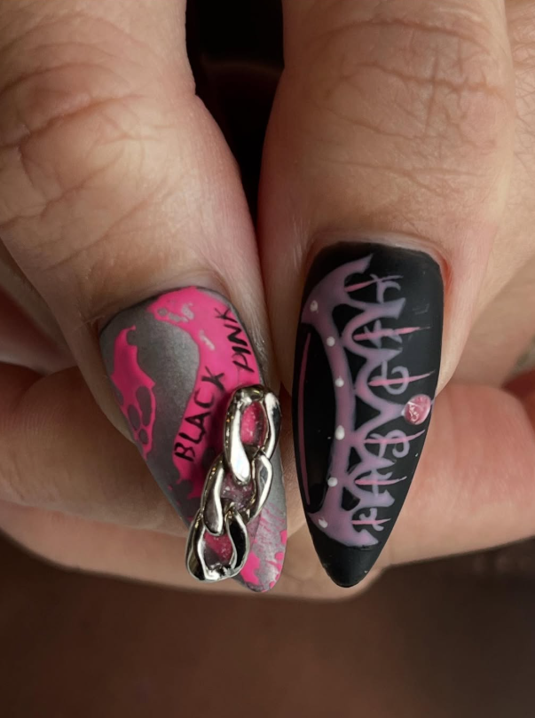 Edgy pink and black nail art with chain accent